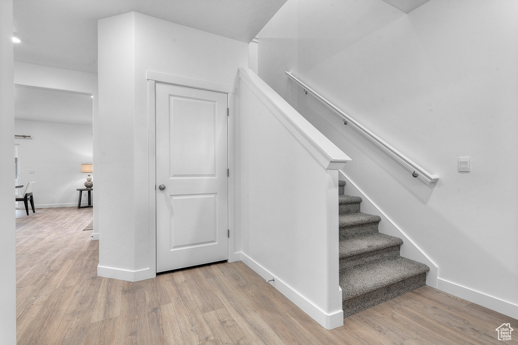 Staircase with baseboards and wood finished floors