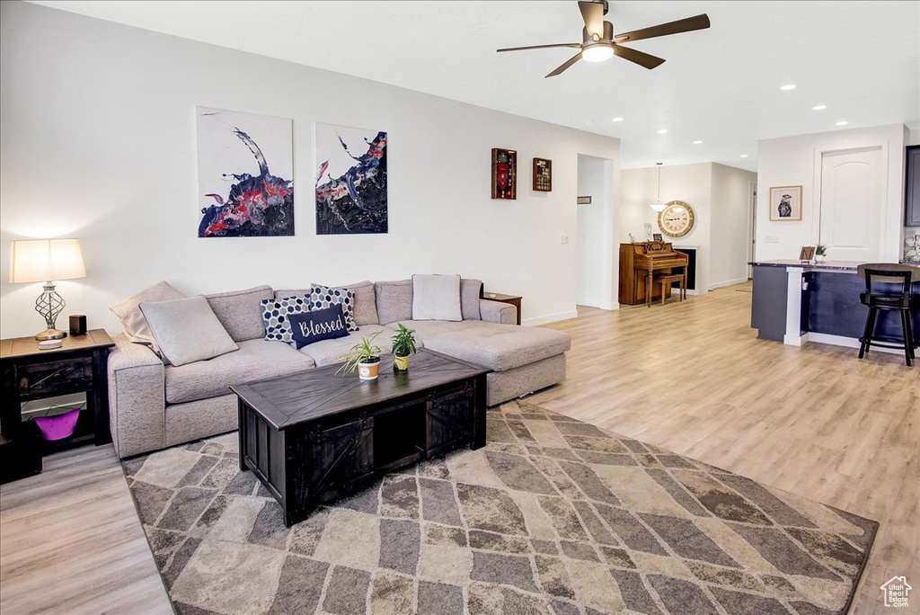 Living area with light wood-style floors, recessed lighting, baseboards, and ceiling fan