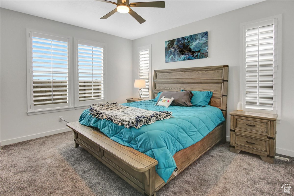 Carpeted bedroom with baseboards and ceiling fan
