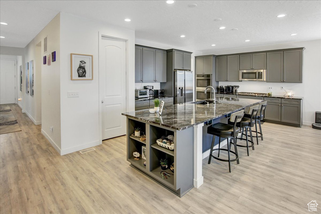 Kitchen featuring a sink, a kitchen breakfast bar, stainless steel appliances, and recessed lighting