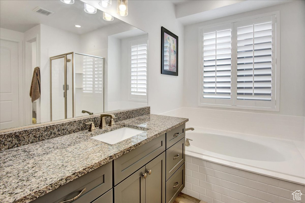 Bathroom featuring vanity, visible vents, plenty of natural light, and a stall shower