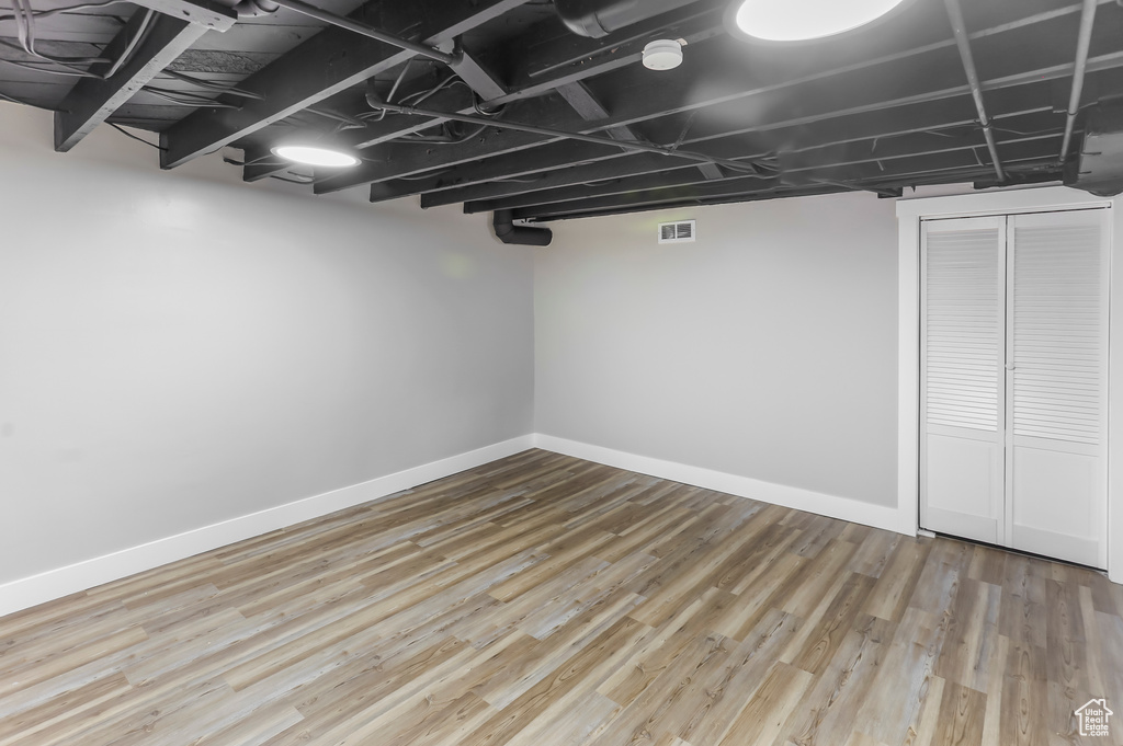 Finished below grade area with baseboards, wood finished floors, and visible vents