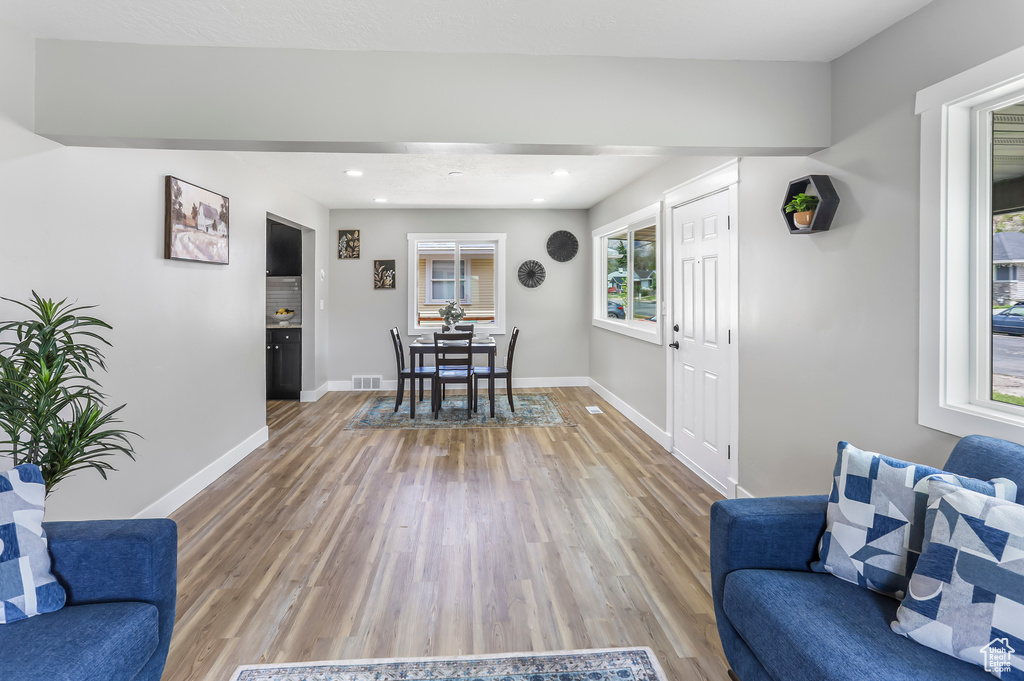 Living area featuring light wood-style floors, baseboards, recessed lighting, and visible vents