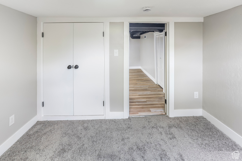 Unfurnished bedroom featuring baseboards, carpet, and multiple closets