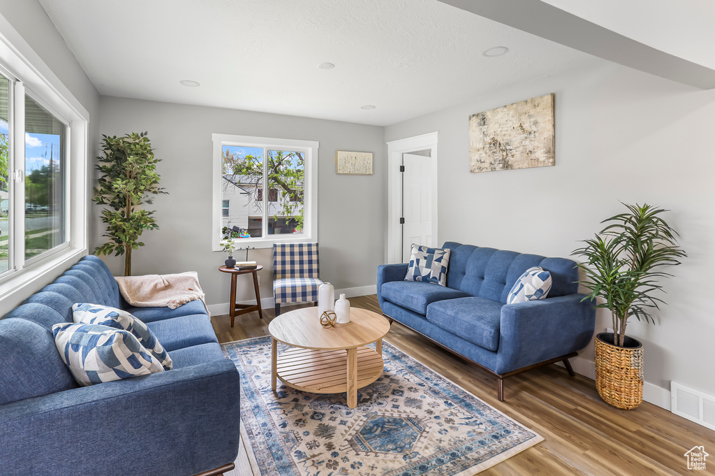 Living area featuring visible vents, recessed lighting, baseboards, and wood finished floors