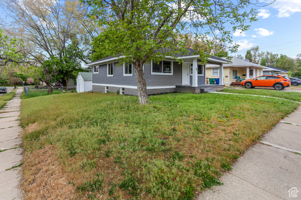 View of front of home featuring covered porch and a front lawn