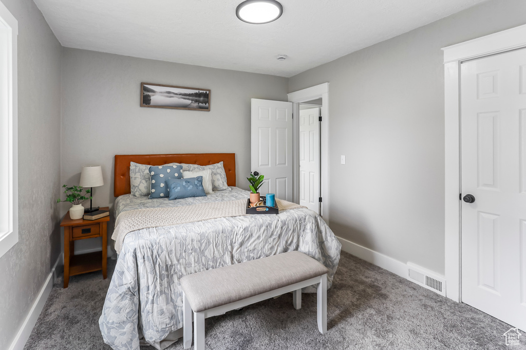 Bedroom with carpet floors, baseboards, and visible vents