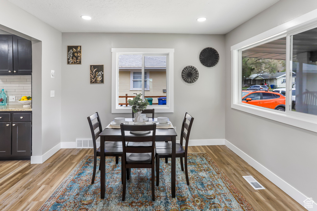Dining area with baseboards, visible vents, and light wood finished floors