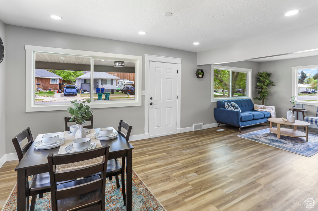 Dining room with visible vents, baseboards, plenty of natural light, and wood finished floors