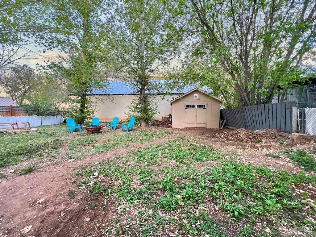 View of yard with fence, an outbuilding, and a shed
