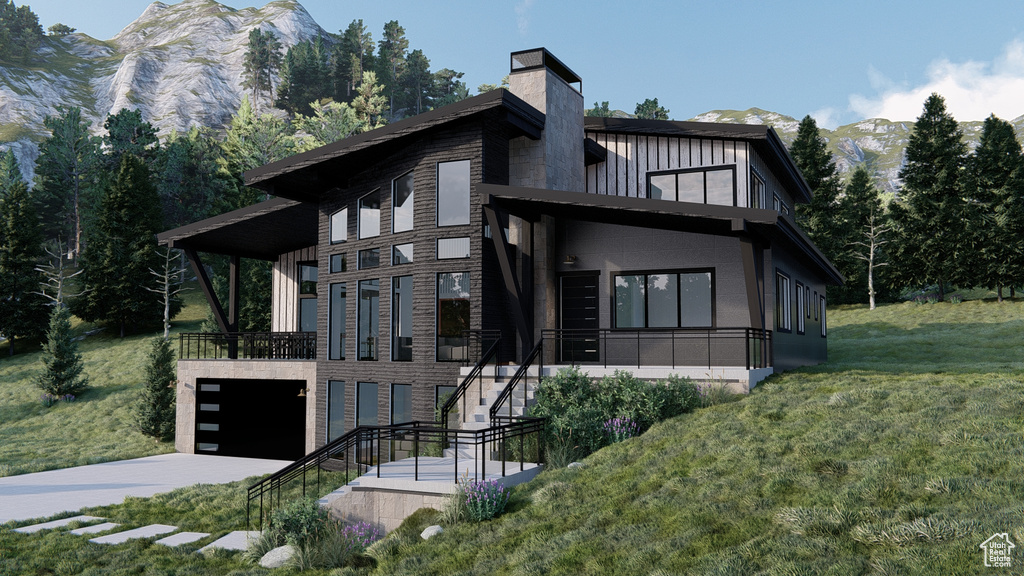 View of front of house with a garage, a front lawn, a chimney, a mountain view, and stairway