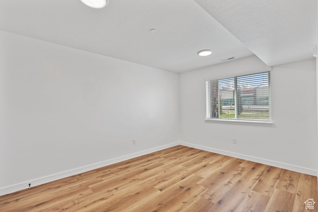 Unfurnished room with light wood-style floors, baseboards, and visible vents