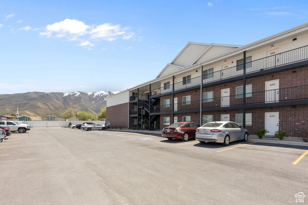View of building exterior featuring a mountain view and uncovered parking