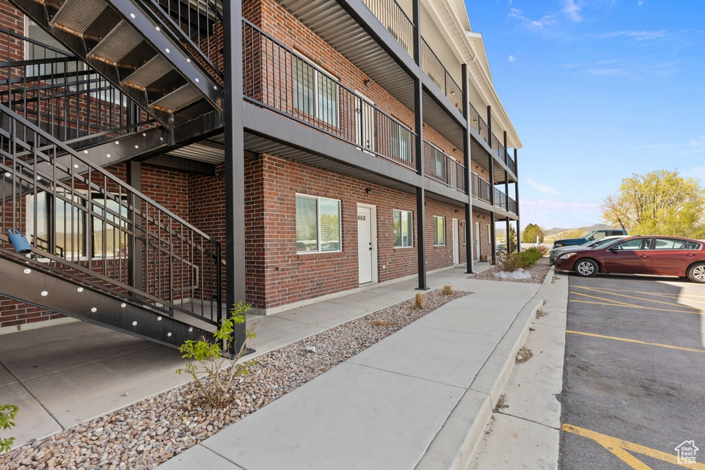 View of building exterior with uncovered parking and stairway