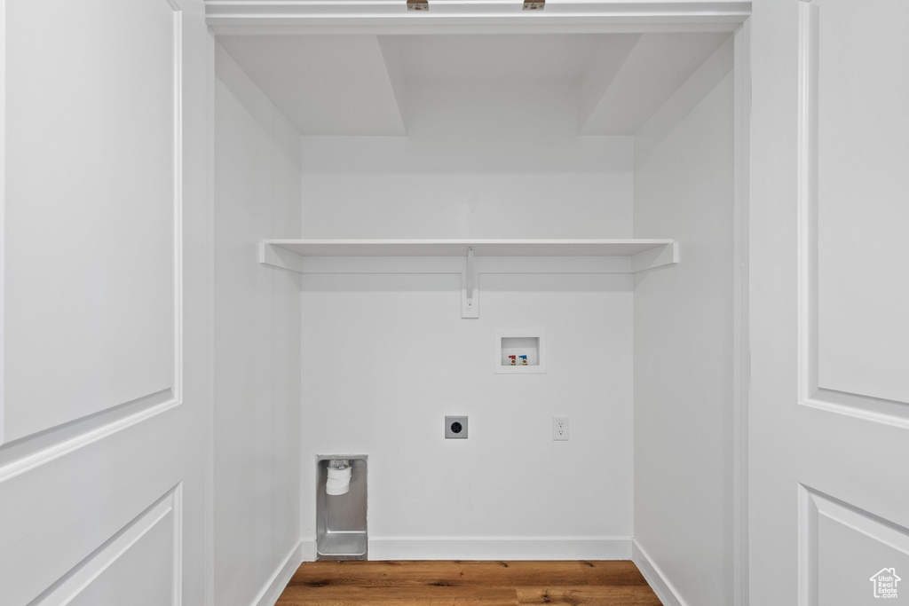 Washroom featuring electric dryer hookup, hookup for a washing machine, baseboards, and wood finished floors