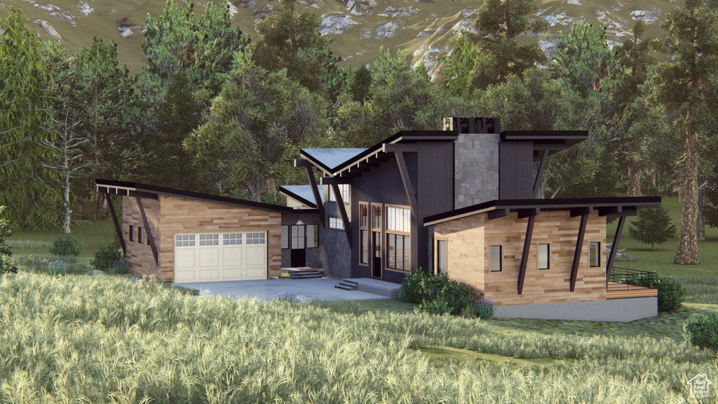 Contemporary home featuring an attached garage and an outdoor structure