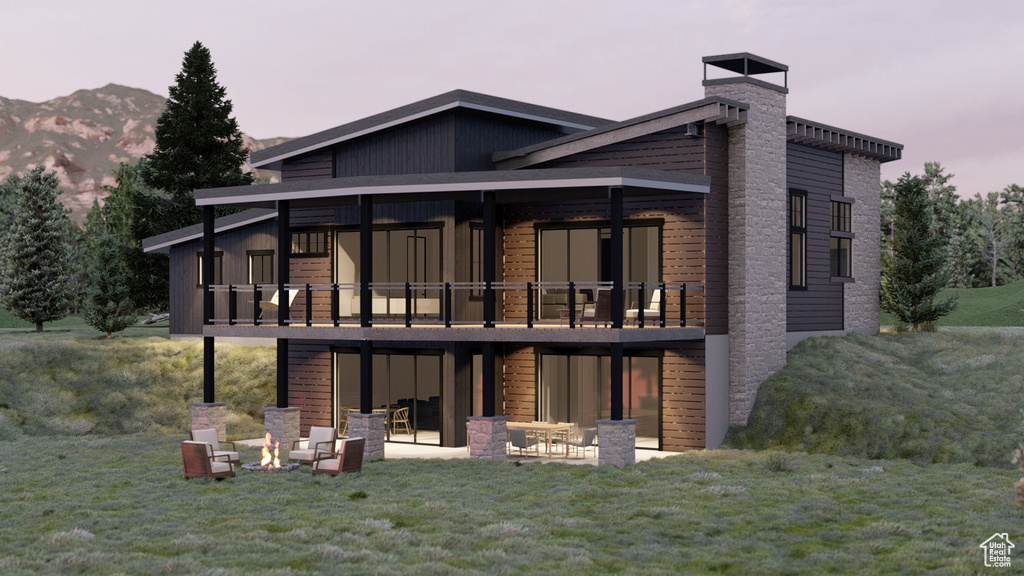 Rear view of house with a patio, a mountain view, a yard, and a chimney