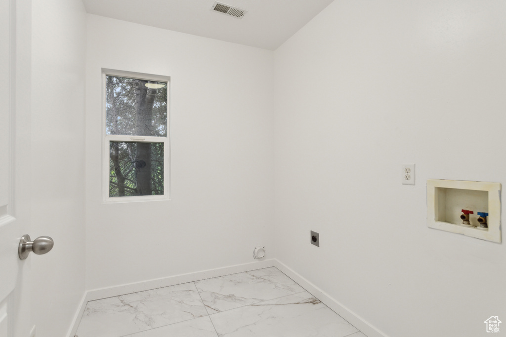 Laundry room with electric dryer hookup, light marble finish flooring, washer hookup, and baseboards