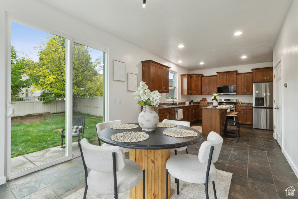 Dining area with stone tile flooring, recessed lighting, and baseboards