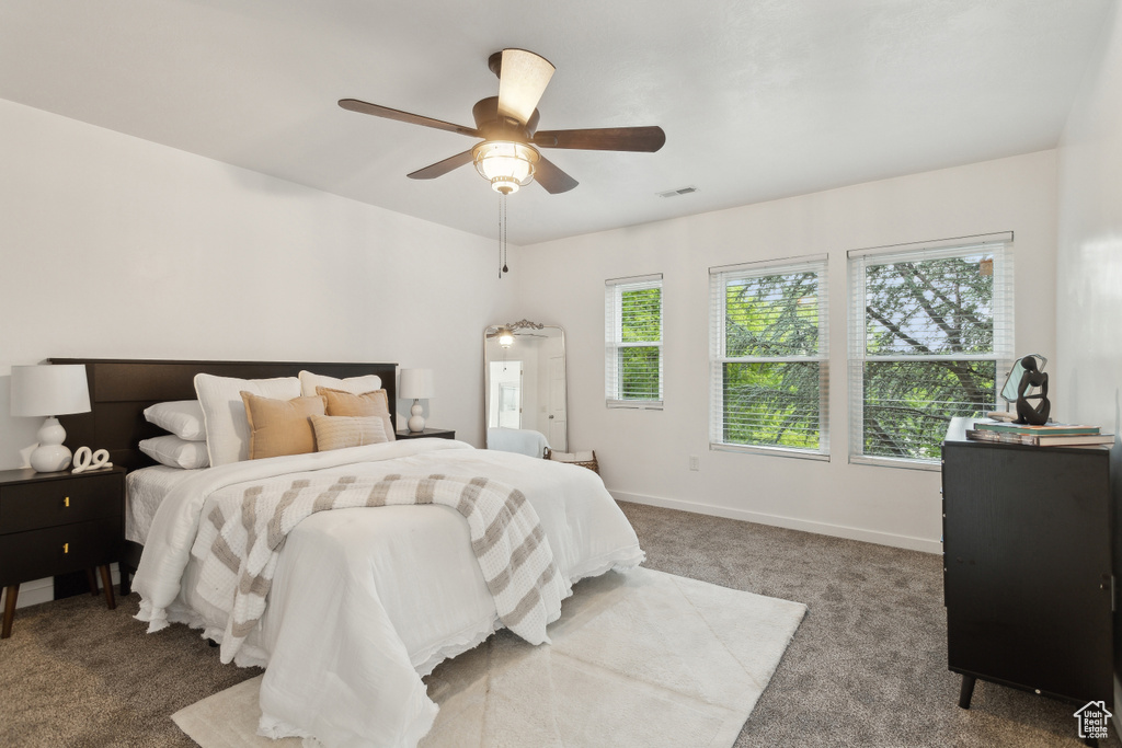 Carpeted bedroom with baseboards and ceiling fan