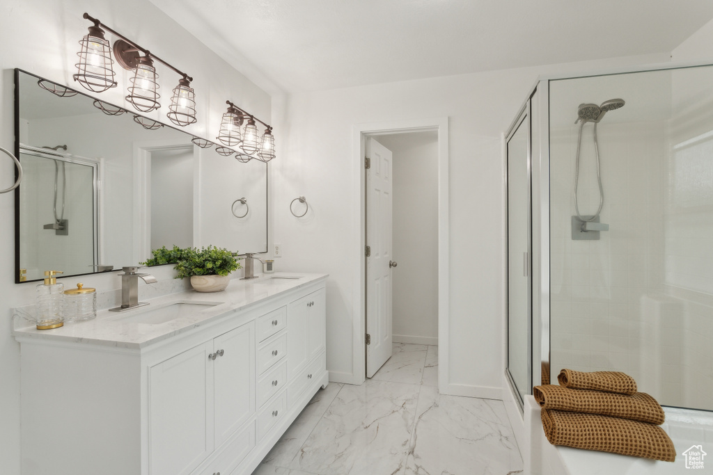 Bathroom with a shower stall, marble finish flooring, double vanity, and baseboards