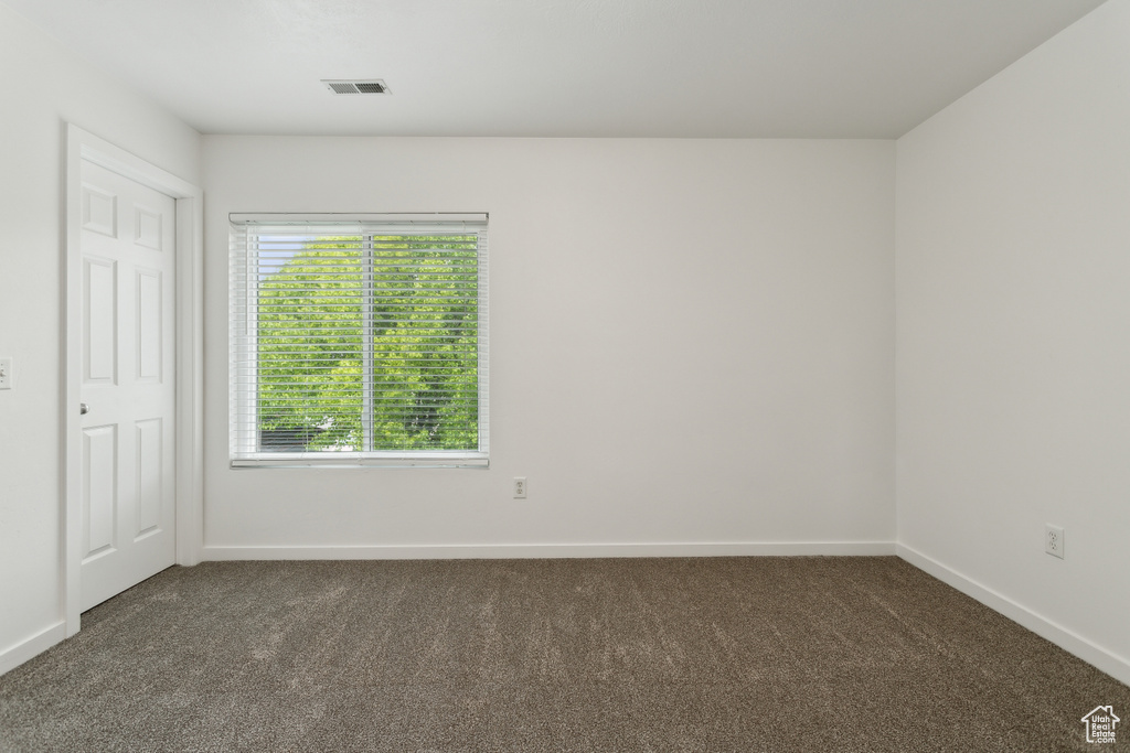Unfurnished bedroom featuring dark carpet and baseboards