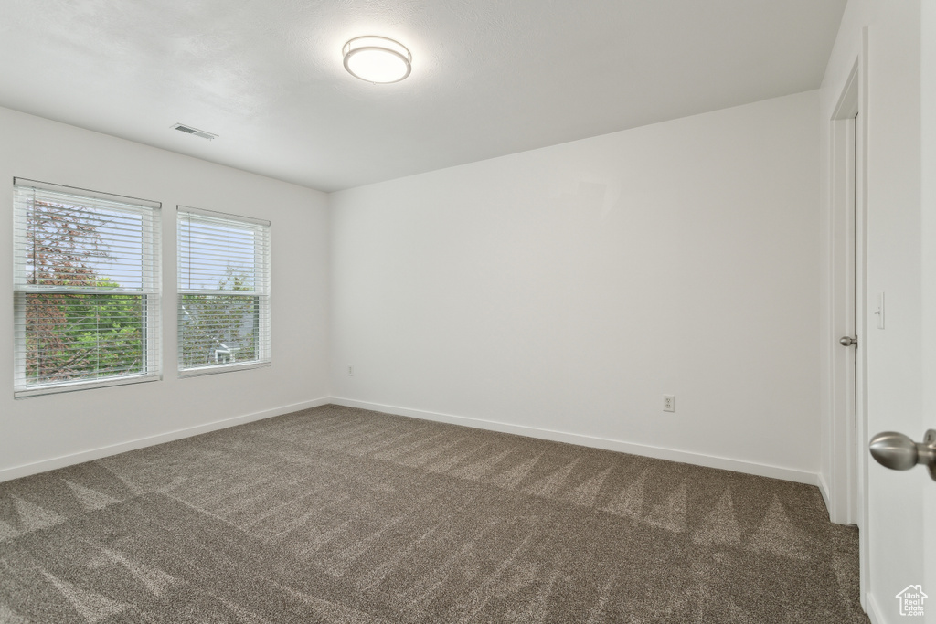 Spare room featuring carpet and baseboards