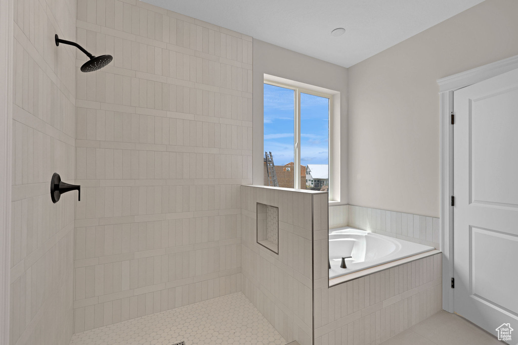 Bathroom featuring tiled shower, a garden tub, and tile patterned floors