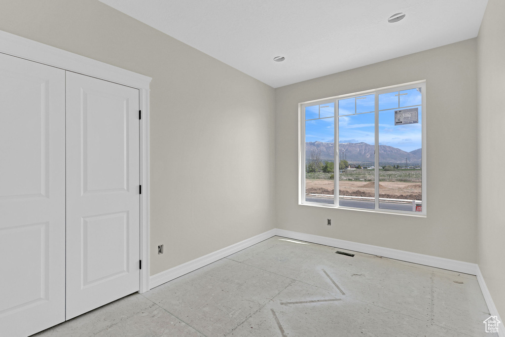 Unfurnished bedroom with baseboards, recessed lighting, and a mountain view