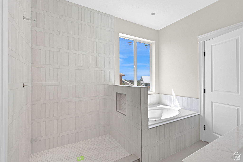Bathroom featuring tile patterned flooring, a tile shower, and a bath