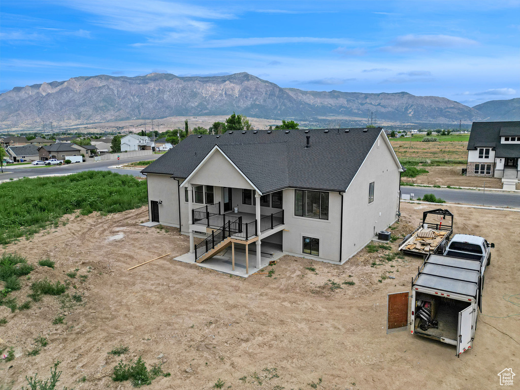 Rear view of house featuring stucco siding and a mountain view