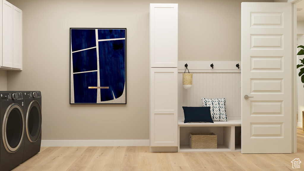 Washroom featuring baseboards, washer and clothes dryer, cabinet space, and wood finished floors