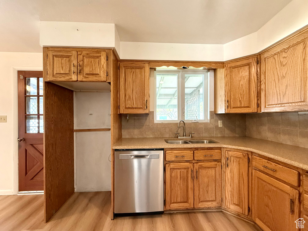 Kitchen with plenty of natural light, a sink, light wood finished floors, and dishwasher