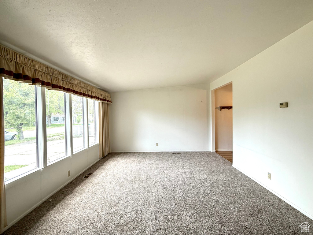 Unfurnished room featuring carpet flooring and visible vents