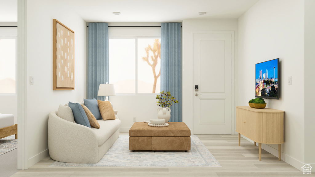 Sitting room with baseboards and light wood-style floors