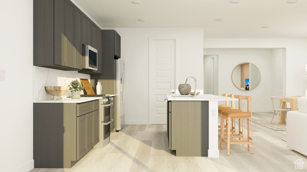 Kitchen featuring a kitchen breakfast bar, white microwave, light countertops, a sink, and double oven range