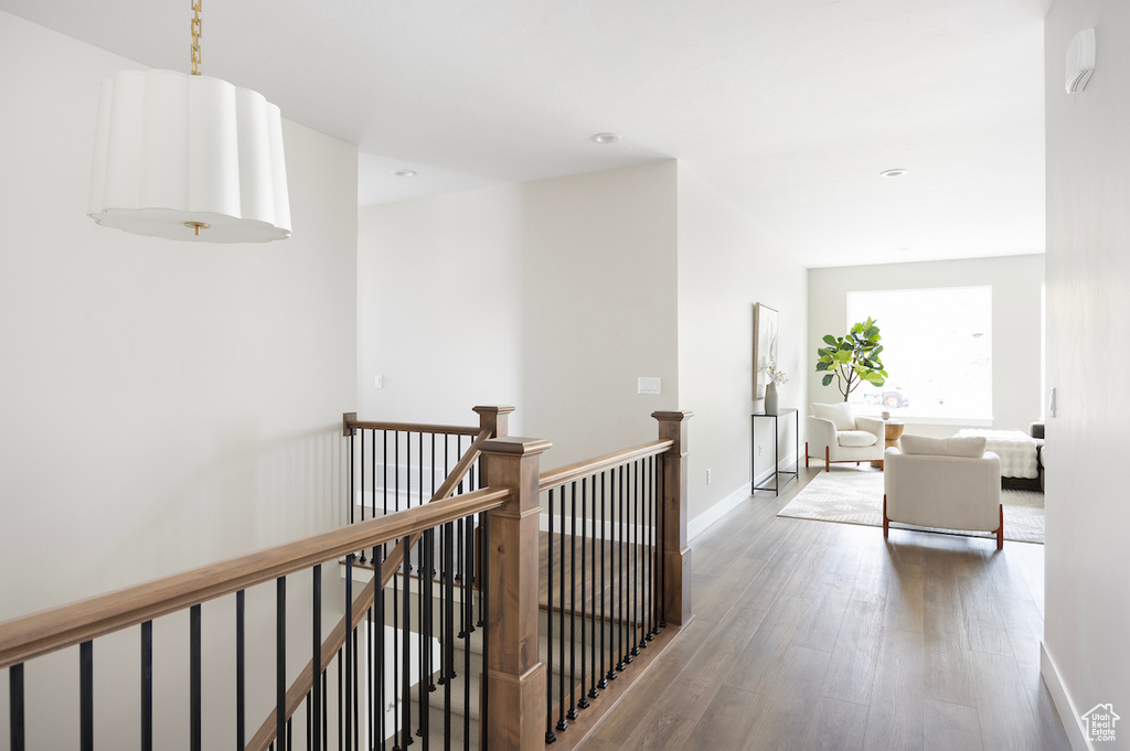 Hallway with recessed lighting, baseboards, an upstairs landing, and wood finished floors