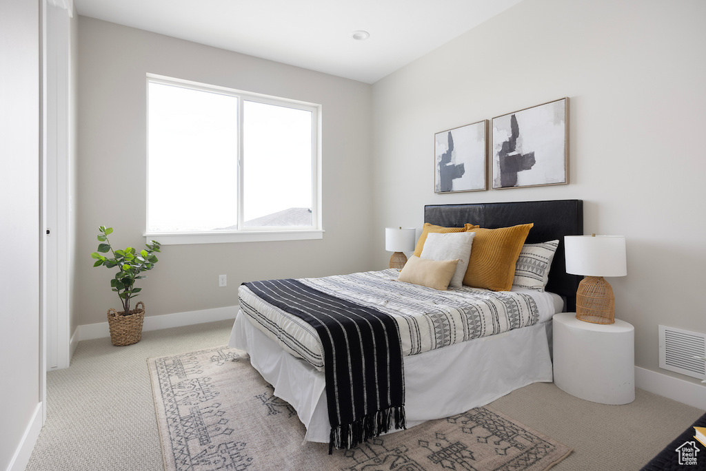 Carpeted bedroom featuring baseboards and visible vents
