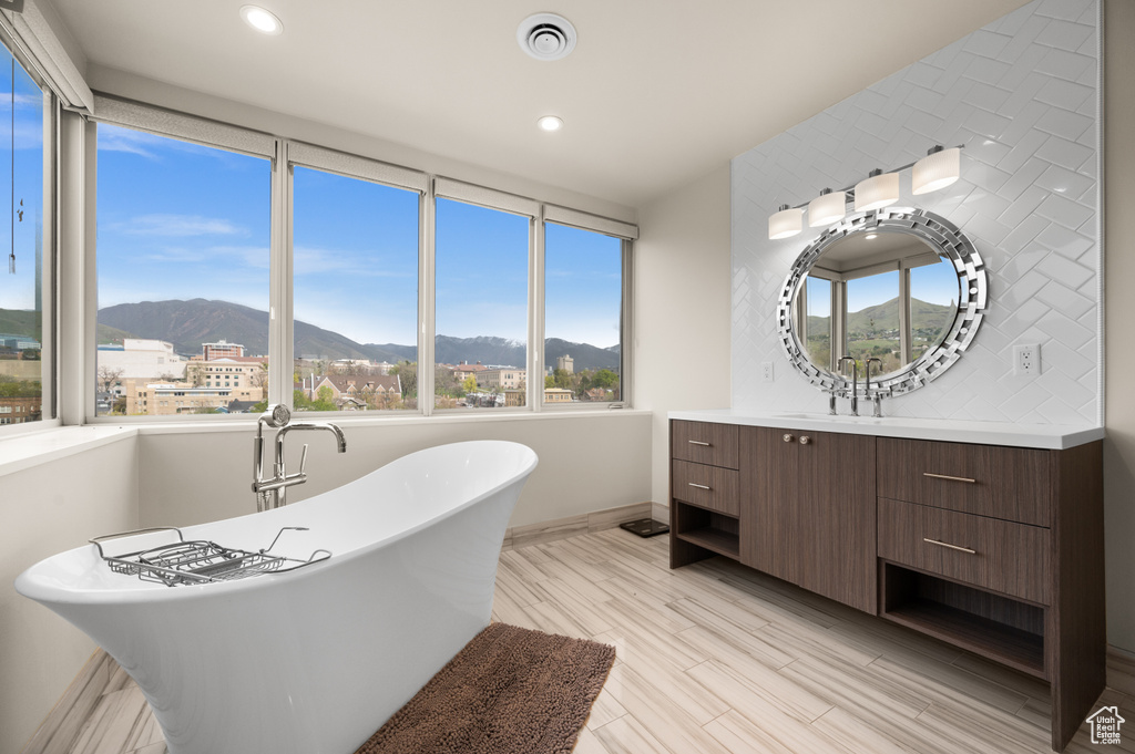 Full bathroom featuring recessed lighting, a freestanding tub, a mountain view, and vanity