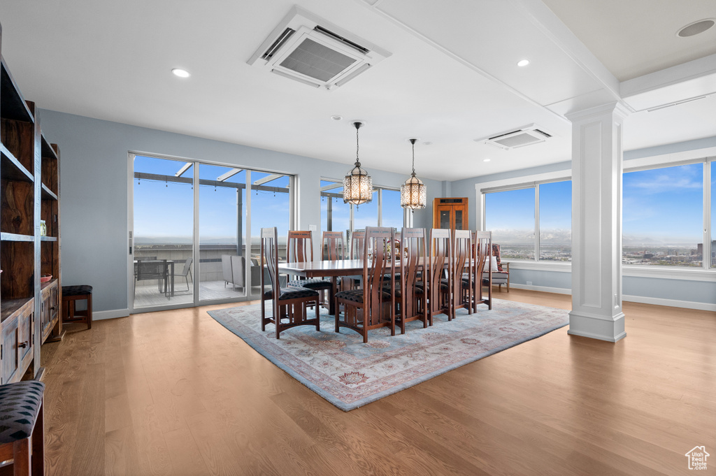 Dining space with baseboards, recessed lighting, ornate columns, and wood finished floors