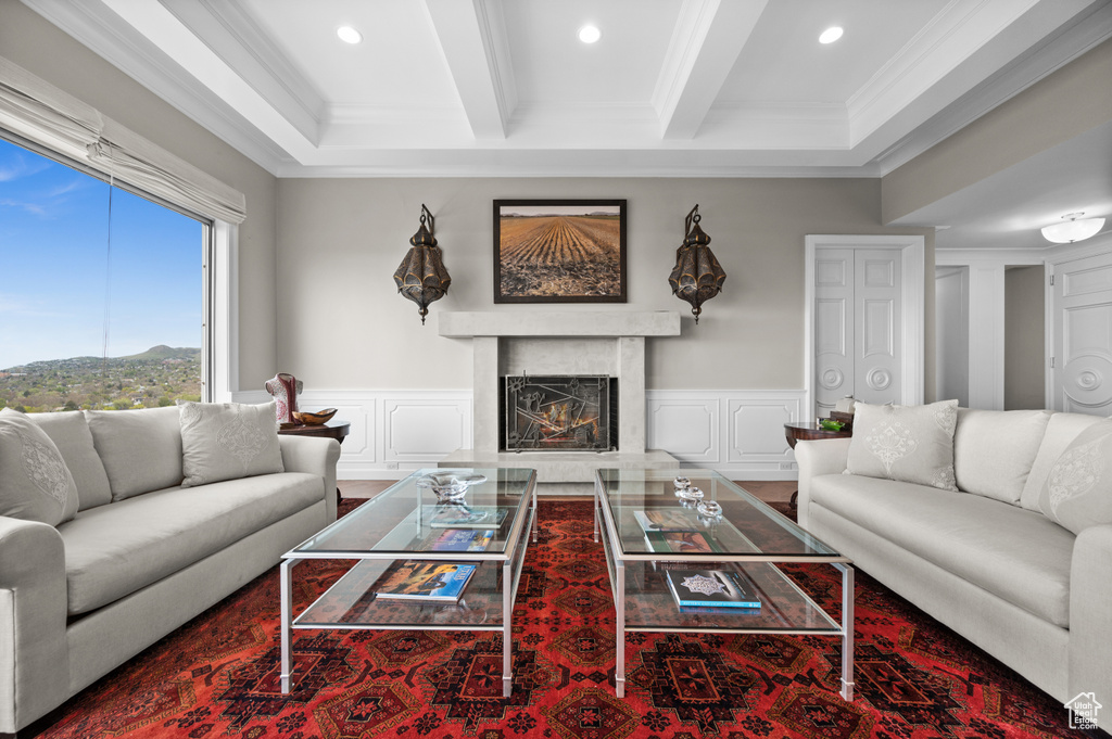 Living room featuring crown molding, a fireplace, a decorative wall, and recessed lighting
