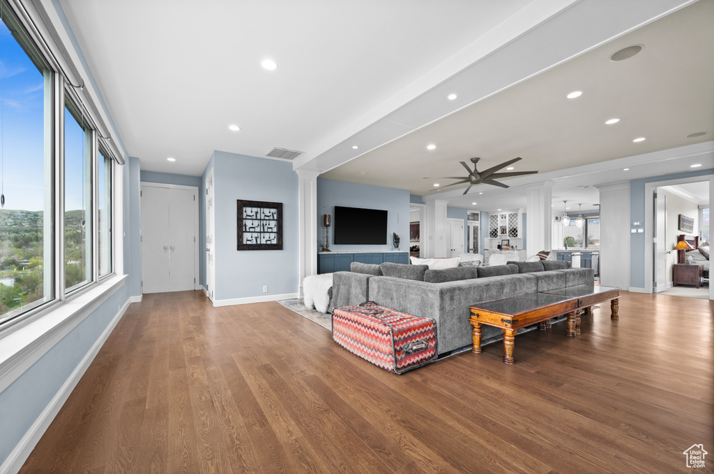 Living room featuring a ceiling fan, visible vents, a healthy amount of sunlight, and wood finished floors
