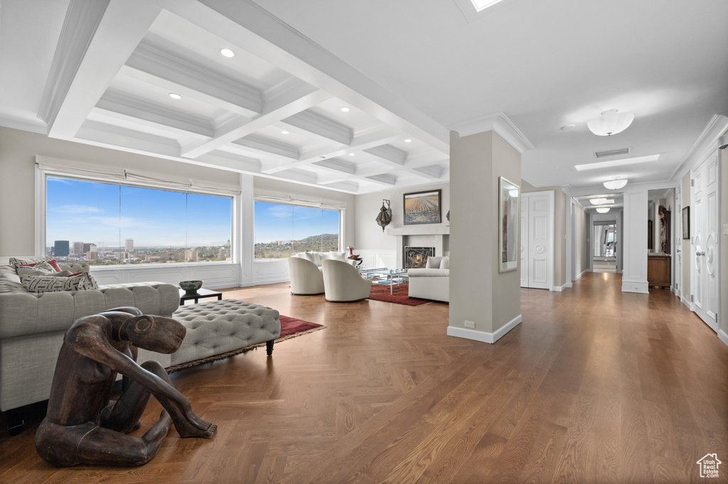 Living area with crown molding, recessed lighting, beamed ceiling, and a warm lit fireplace