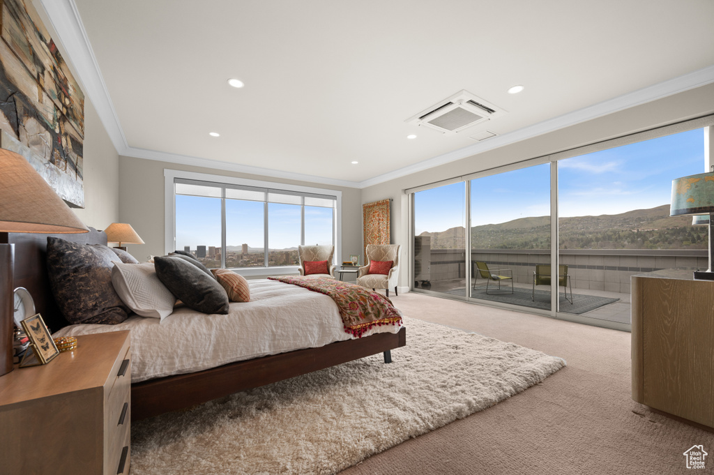 Bedroom with ornamental molding, carpet flooring, a mountain view, and access to exterior