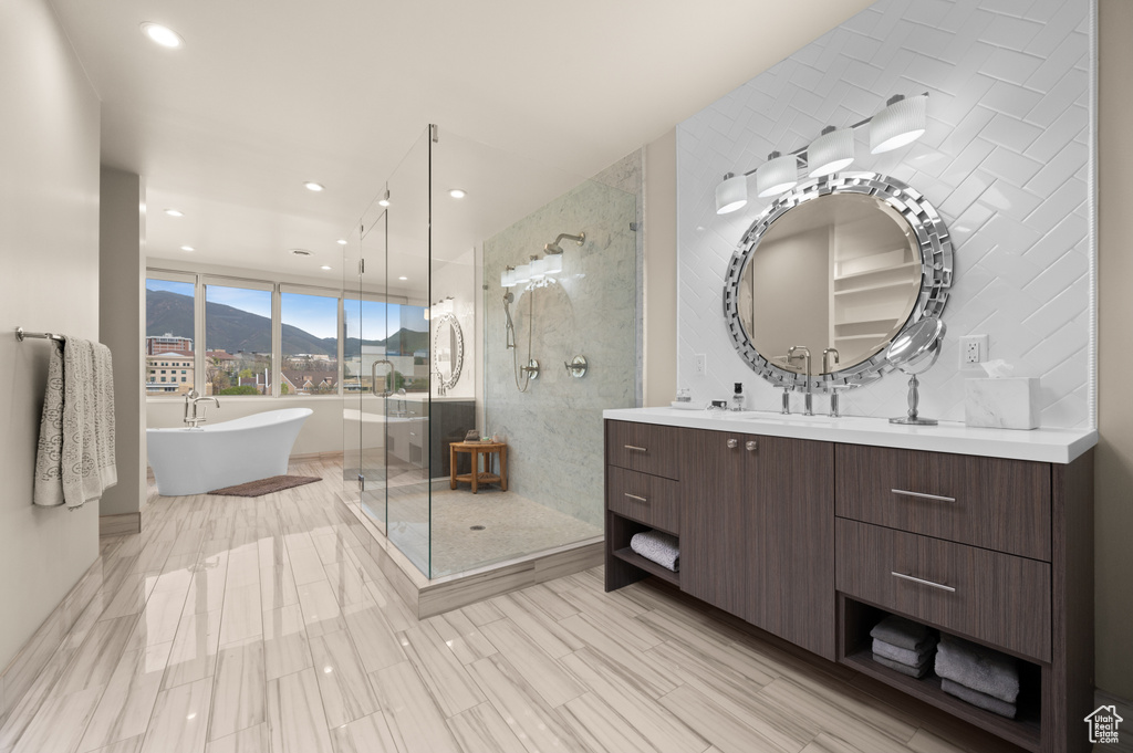 Bathroom featuring vanity, a soaking tub, a shower stall, and a mountain view