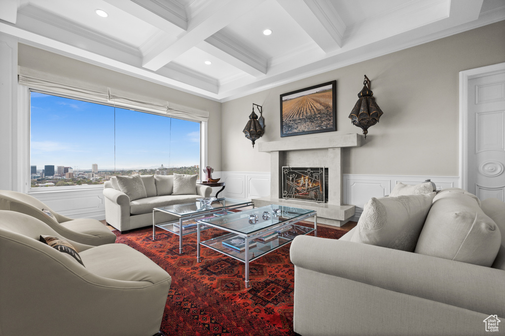 Living room featuring crown molding, a fireplace, beam ceiling, coffered ceiling, and recessed lighting