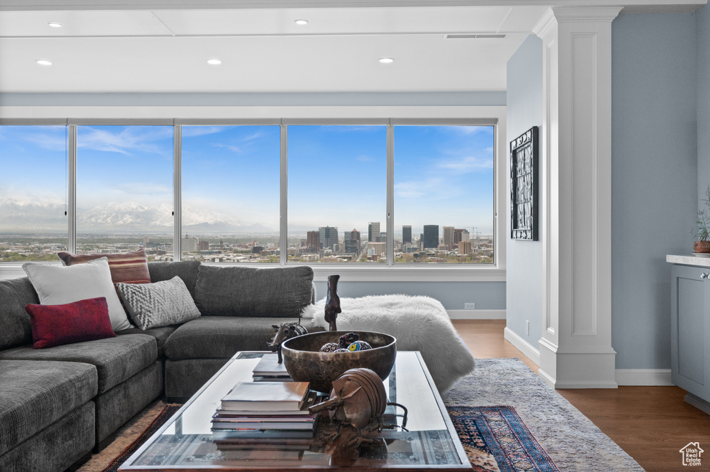 Living room with a view of city, recessed lighting, baseboards, decorative columns, and wood finished floors