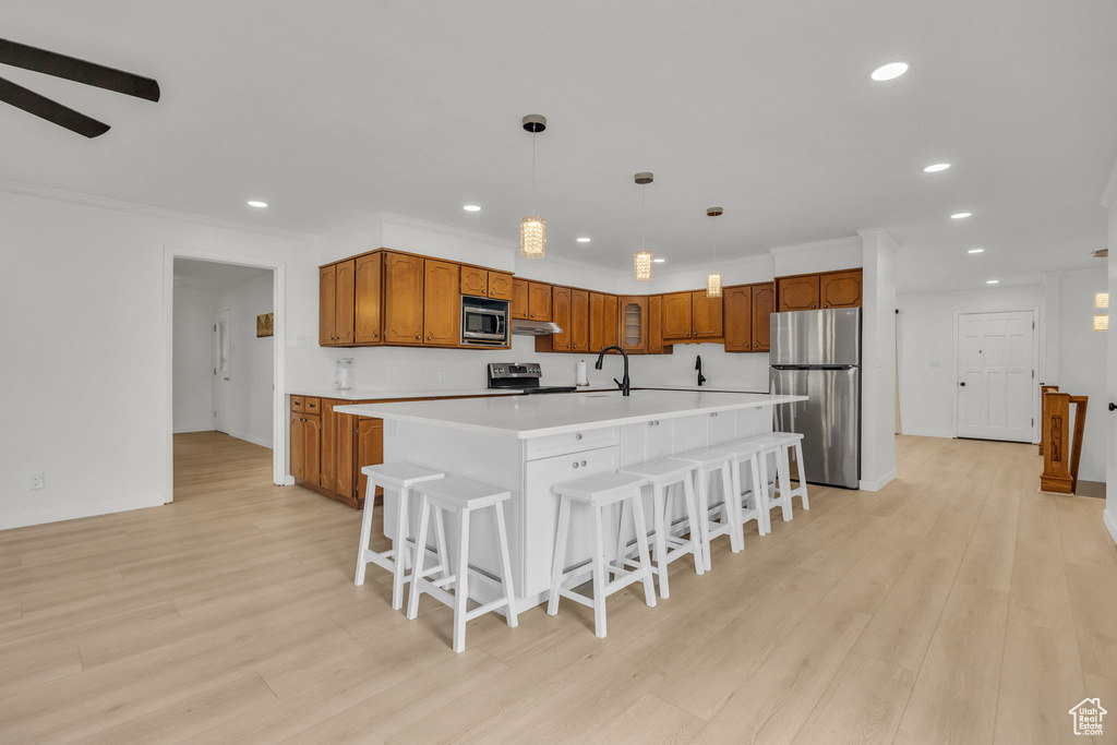 Kitchen featuring appliances with stainless steel finishes, brown cabinetry, and recessed lighting