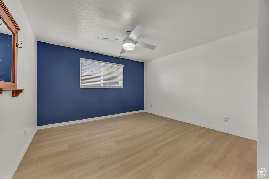 Unfurnished room featuring baseboards, ceiling fan, and wood finished floors