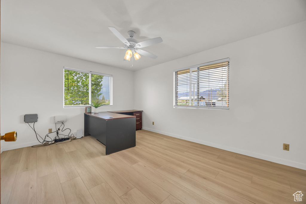 Unfurnished office with baseboards, light wood finished floors, and ceiling fan